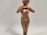 statue en bronze représentant une femme portant ses mains à son visage
