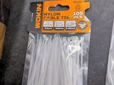 a package of nylon cable ties on a table next to a pair of scissors