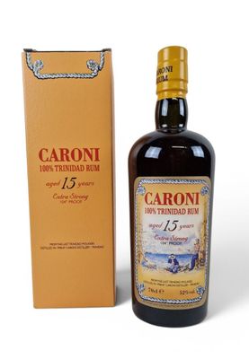 a bottle of caroni rum next to a cardboard box