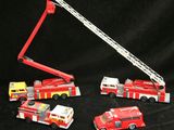 quatre camions de pompiers miniatures et une grue sur fond noir