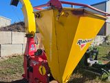 an image of a yellow and red machine in the grass