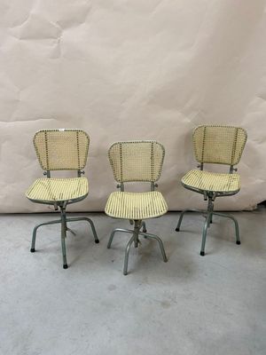 three chairs sitting on top of each other in front of a white backdrop