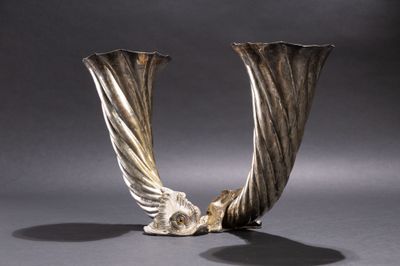deux vases en argent posés l'un à côté de l'autre sur une table