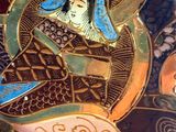 a close up of a decorative plate with a woman on it