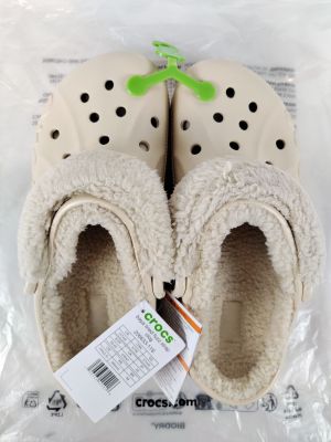 deux paires de pantoufles Crocs dans un sac en plastique