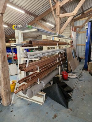 de nombreux rouleaux de bois empilés sur un rayonnage dans un entrepôt