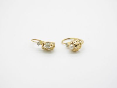 une paire de boucles d'oreilles en or jaune serties de diamants sur fond blanc