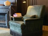 a green chair sitting in front of a fireplace in a living room
