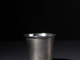 a silver cup sitting on top of a black table