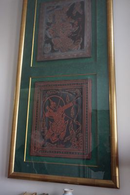 deux tableaux encadrés accrochés au mur au-dessus d'un vase