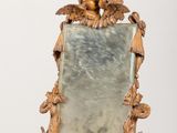 un miroir orné de deux oiseaux, posé sur une table