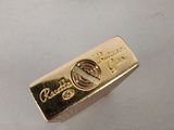a gold bar sitting next to a red velvet case