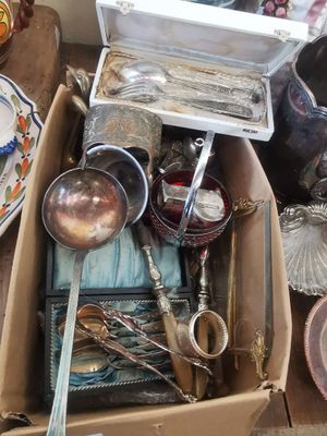 une boîte pleine d'argenterie posée sur une table