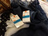 a box of sunscreen sitting on a bed next to a pair of jeans