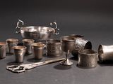 a lot of silver cups and spoons on the table