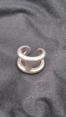 silver ring with a hole in the middle of it on a black cloth