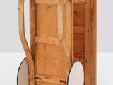 a small wooden cart with wheels on a white surface