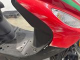 a red scooter with a green and red stripe on it
