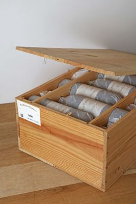 a wooden box with a bunch of rolls of toilet paper in it