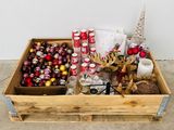 une boîte en bois remplie d'une sélection de décorations de Noël