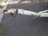 an old rusted boat anchor on the side of the road