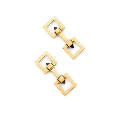 une paire de boucles d'oreilles carrées en or sur fond blanc