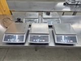 several electronic scales on a table in a warehouse setting