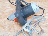 a small electric drill on the floor next to other tools