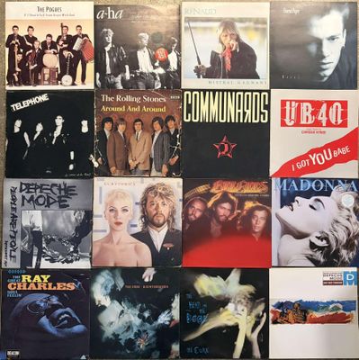 the wall is covered with various album covers of various music