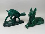 deux figurines vertes représentant un chien et un chat, posées sur un fond blanc