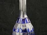 a blue glass decanter sitting on a black surface