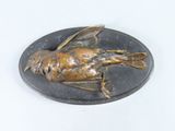 a statue of a bird on a plate on a table