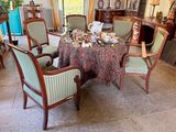 many chairs around a table with a table cloth on it