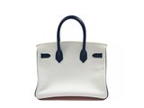 a white and blue handbag sitting on top of a white surface