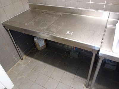 un plan de travail en acier inoxydable dans des toilettes publiques