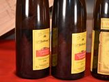 three bottles of wine are lined up on a red table