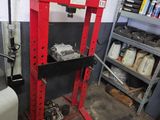 une photo d'une machine dans un garage, entourée de nombreux outils