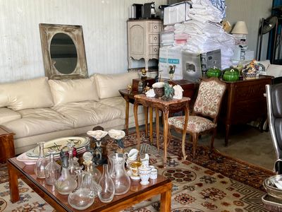 un salon avec un canapé, une table, des chaises et un miroir