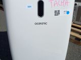 une poubelle sur laquelle est collé un autocollant, devant un immeuble