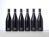 six bottles of wine lined up in a row on a table