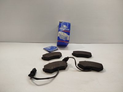 Les plaquettes de frein sont posées sur la table, à côté d'un sac de lait.