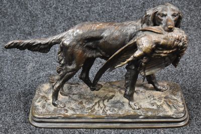 bronze statue of a dog carrying a duck in its mouth