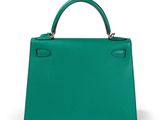 a green leather handbag on a white background