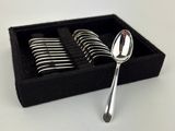 des cuillères en argent dans une boîte noire posée sur une surface blanche