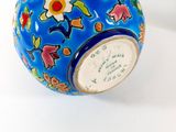 a blue vase with flowers on it sitting on a table