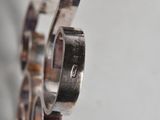 a person holding a silver bracelet that has a number on it