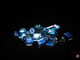 quelques morceaux de verre bleu sont éparpillés sur une surface noire