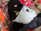 a suitcase full of clothes and clothes sitting on the floor