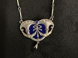 a close up of a necklace with a heart shaped pendant on it