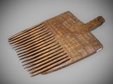 an old wooden comb with a wooden handle sitting on a table